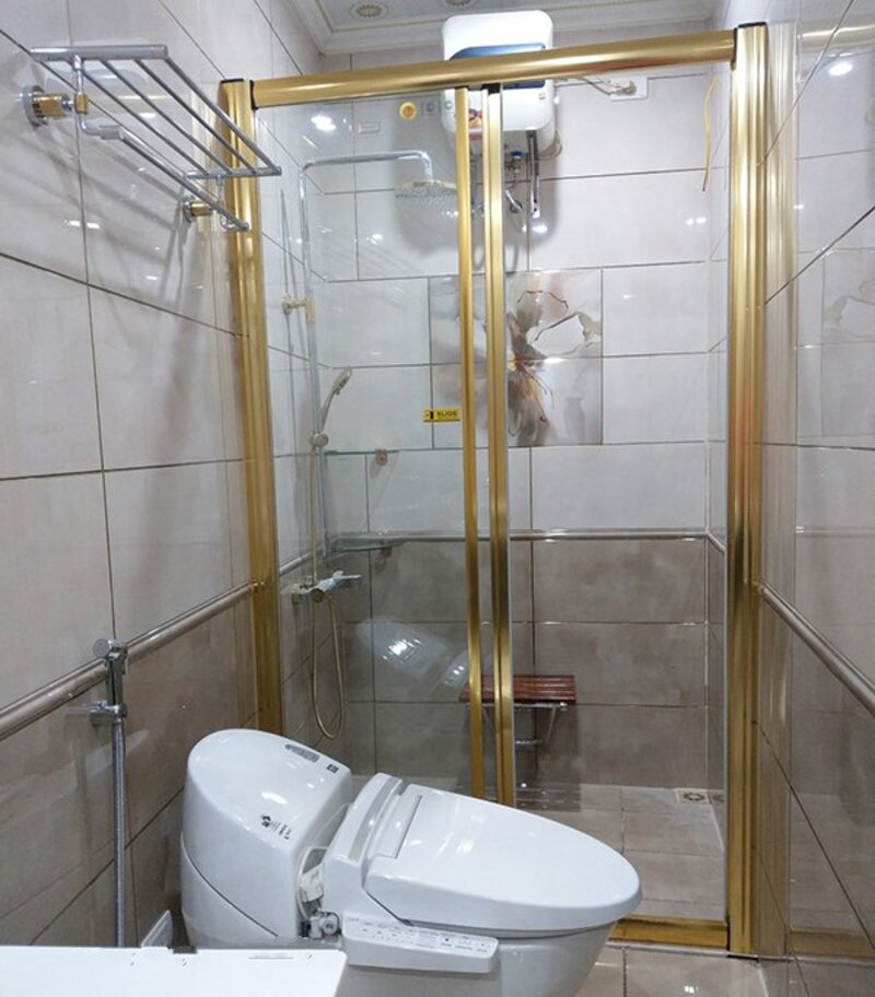 Cửa kính phòng tắm có khung cửa và phụ kiện mạ vàng sang trọng